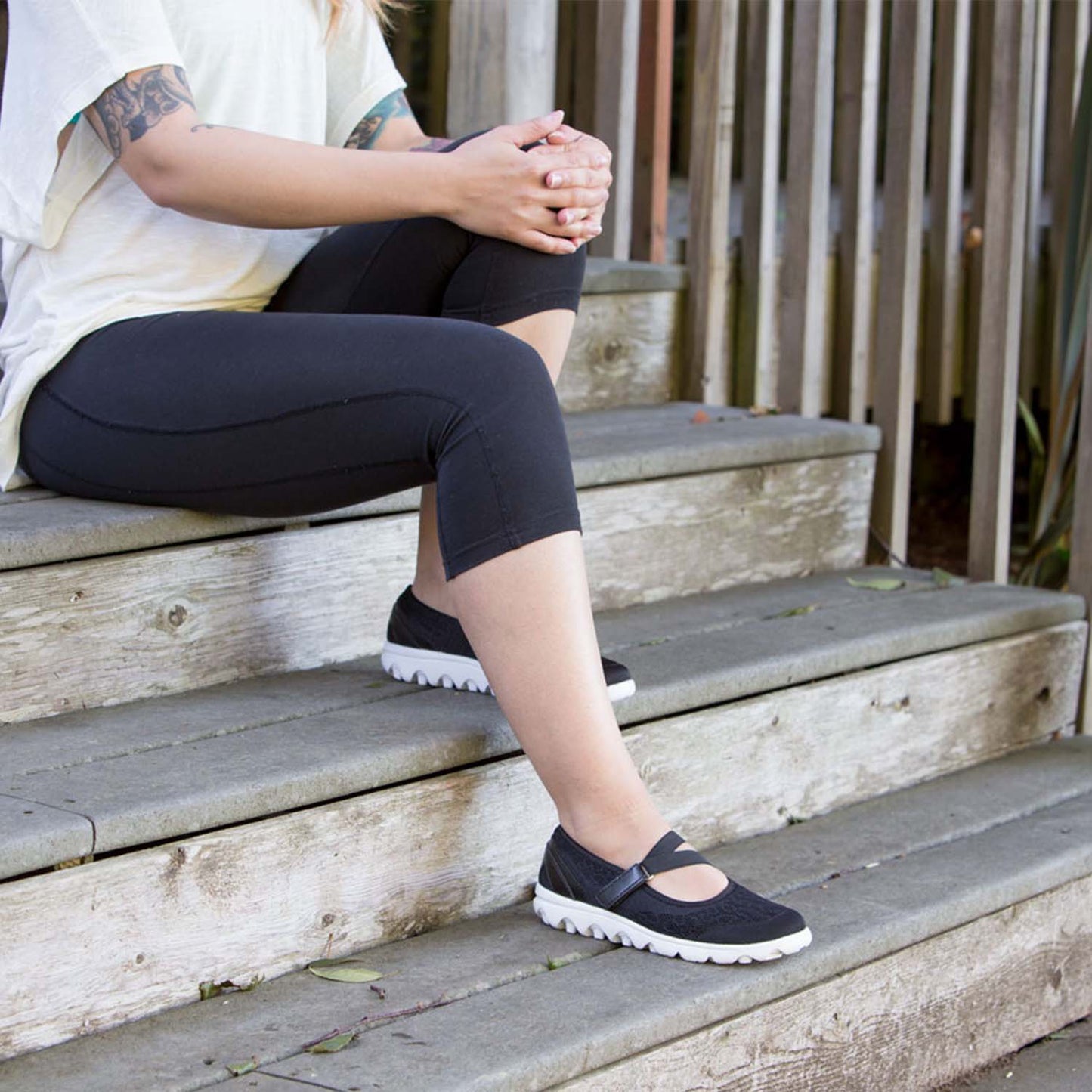 Woman sitting on stairs outside while wearing the TravelActiv Mary Jane in Black