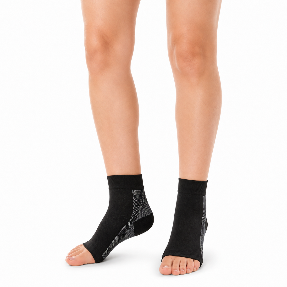 A person's feet and lower legs wearing black ankle support sleeves with gray textured side panels, shown against a plain white background.