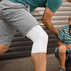 Lifestyle image of man outside with son wearing the Actimove Mild Knee Support