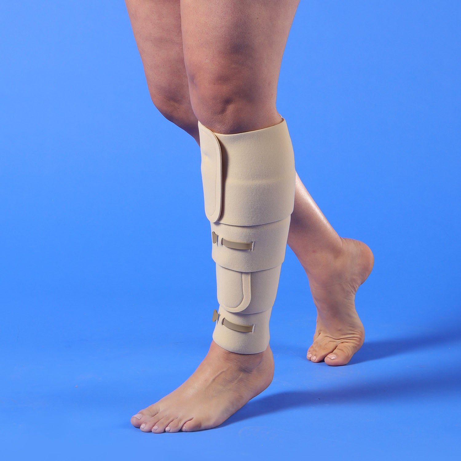 Thuasne Biflex Self Adjust leg wrap on a person's leg against a blue background
