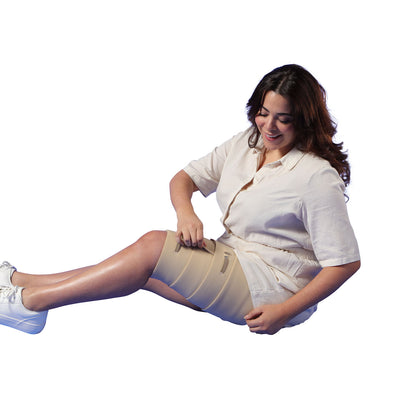 Woman wearing a compression garment on her leg with a white background
