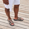 Lifestyle- man wearing the Propet Men's Hatcher Sandals in Dark Grey from angled top-down view outside