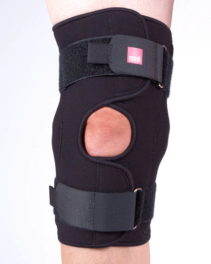 Black knee brace on a person's leg with a white background