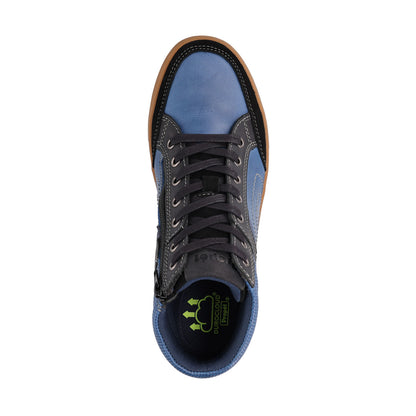 A top-down view of a mid-top sneaker with a blue leather upper, dark gray suede overlays, black laces, and a brown gum sole, shown on a white background.