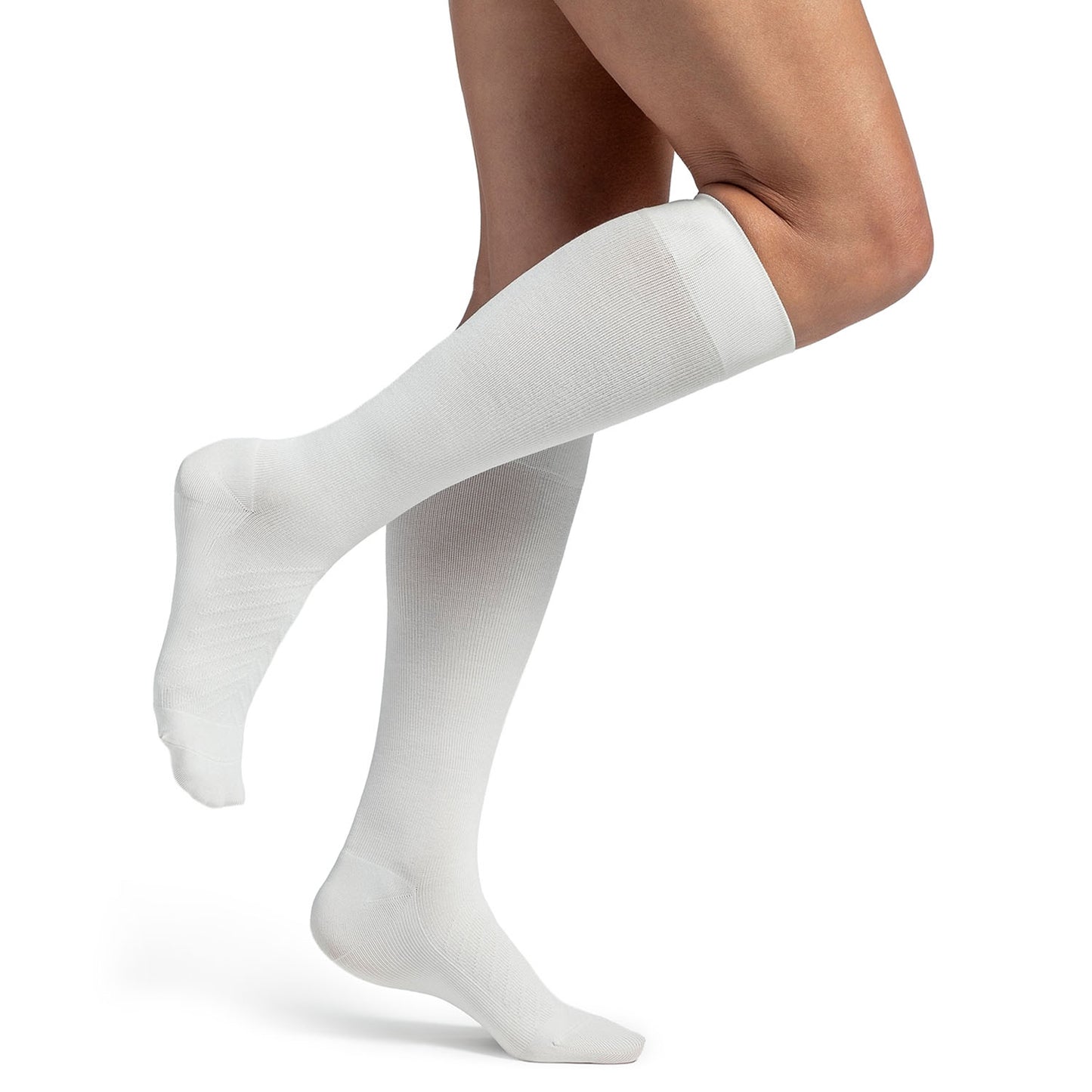 White knee-high socks worn by a person on a white background