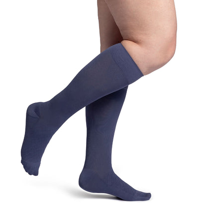 Navy blue knee-high socks worn by a person on a white background
