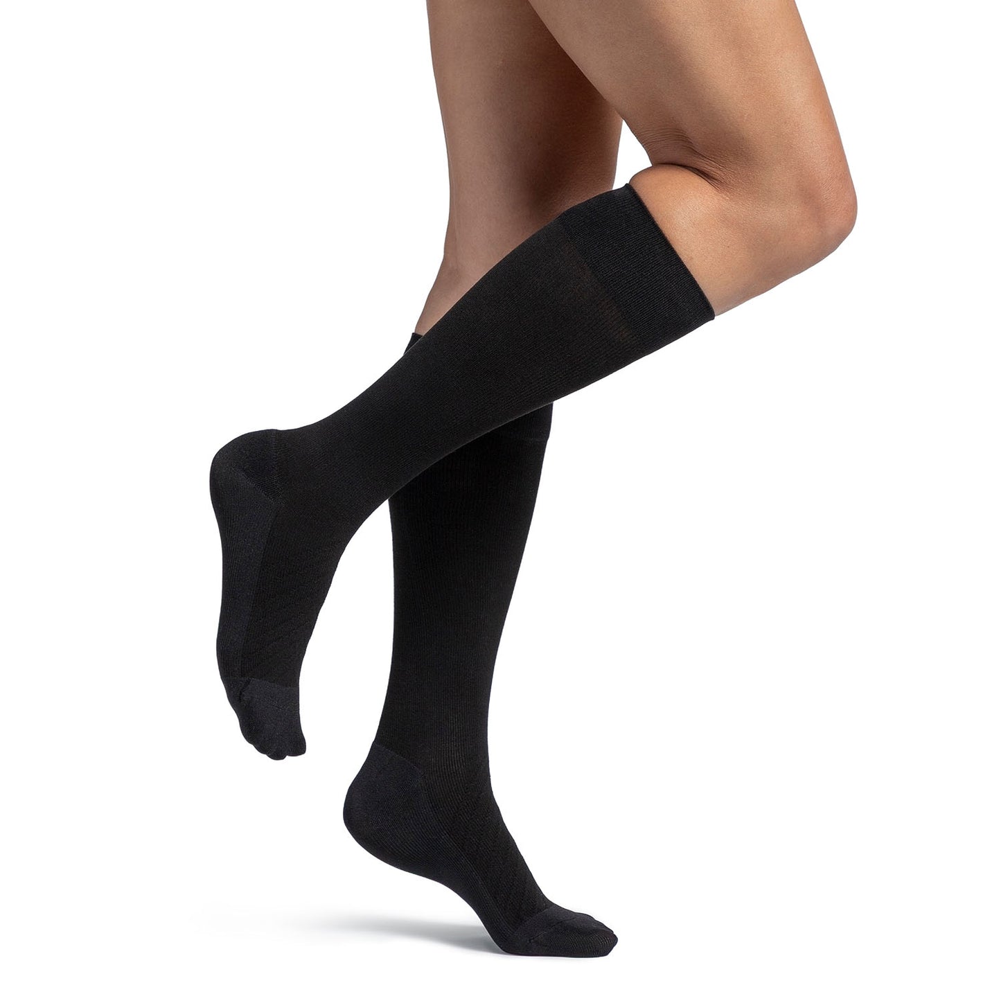 Black knee-high socks worn by a person on a white background