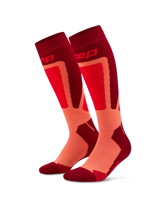 CEP Men's Ski Thermo Tall Socks - A pair of athletic knee-high socks in red and orange, featuring a textured knit design and the brand logo 'zep' on the upper cuff, set against a plain white background.