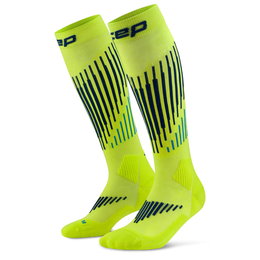 CEP Men's Ski Touring Merino Tall Socks - A pair of bright neon yellow athletic socks with black and teal graphic stripes, shown on a clean white background.