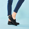 Side view of woman wearing the All Black Propet Women's TravelActiv Slip-On